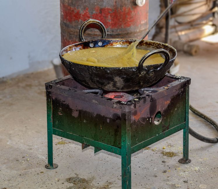 Cast iron and carbon steel woks displayed side-by-side on marble countertop beside electric stovetop