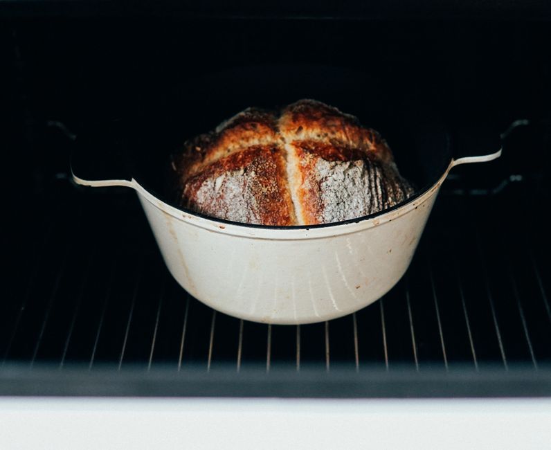 5 Dutch Oven Mistakes That Ruin Budget Pans Damaged enameled Dutch oven with chips and rust on marble counter near cleaning supplies