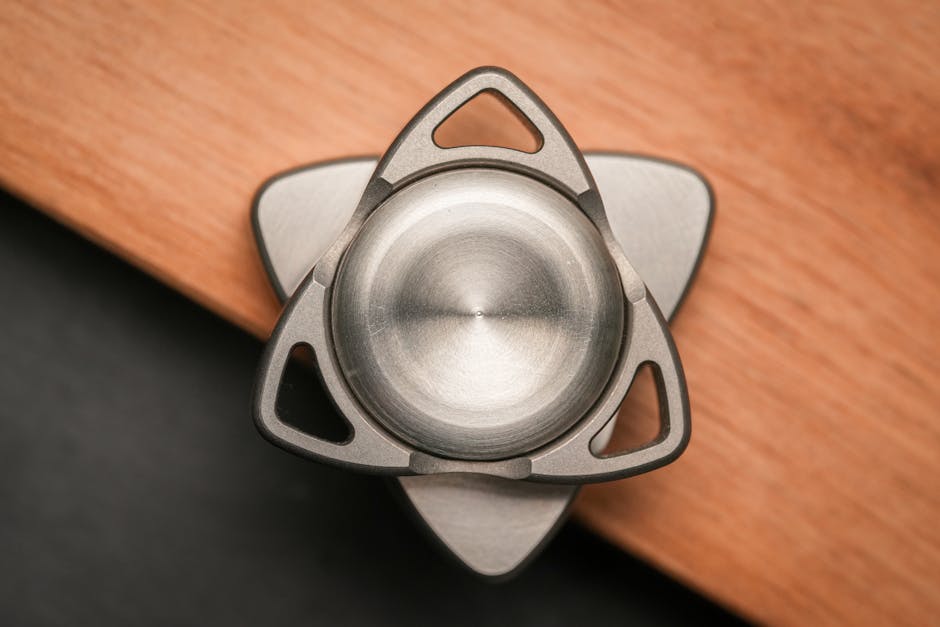 Tri-ply and five-ply stainless steel saucepans displayed side-by-side with visible cross-section layers on marble countertop.